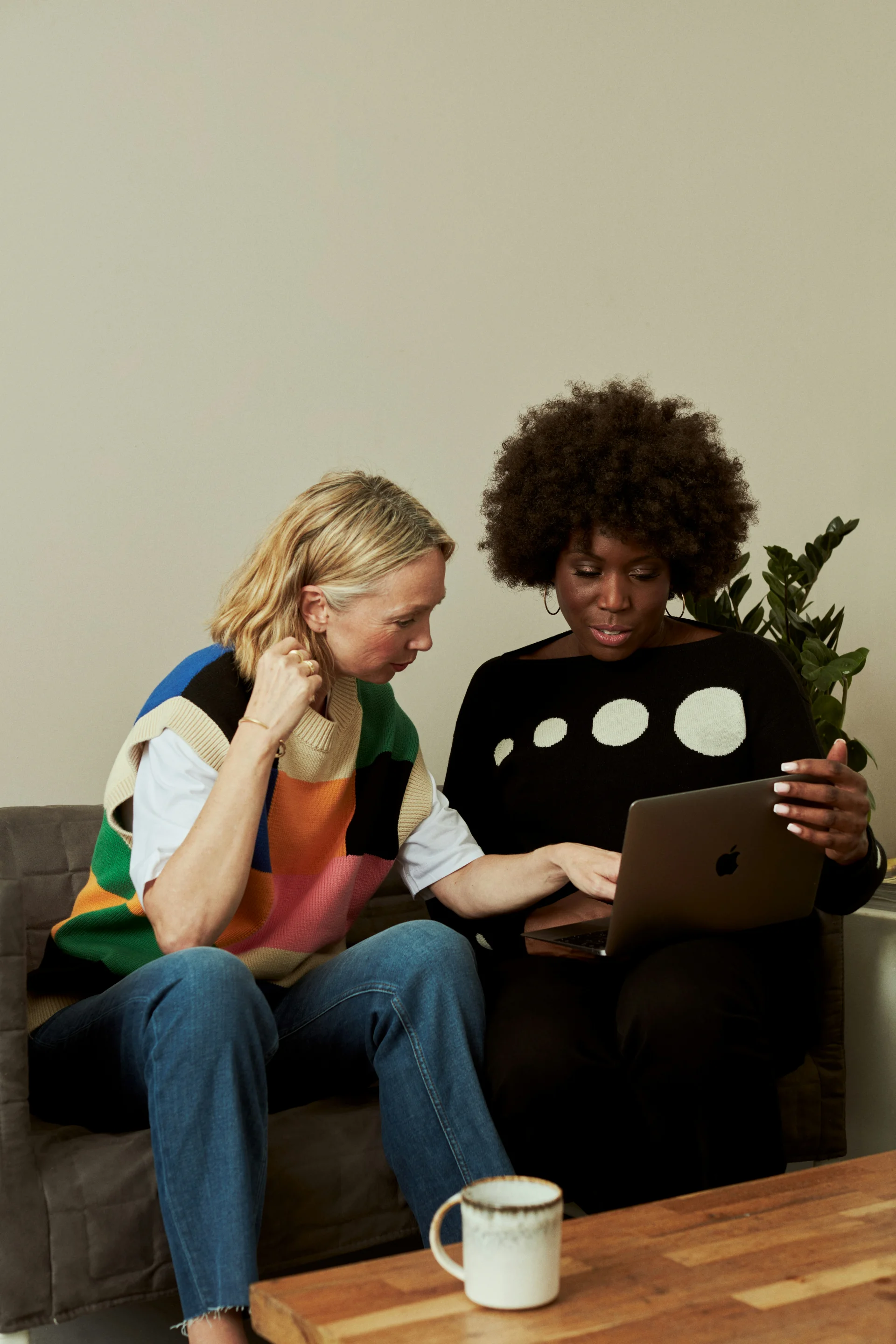 twee mensen die samen in de zetel zitten en aan een computer werken