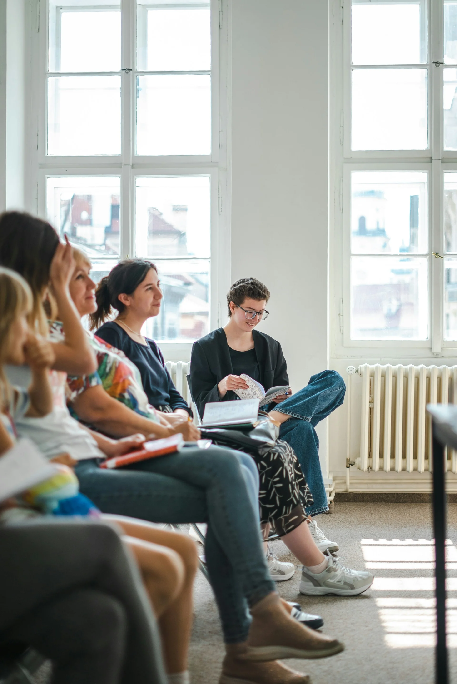 een groep mensen die les volgen, met notities op hun schoot