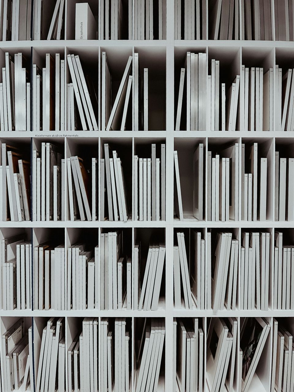 Een boekenkast met allemaal witte boeken